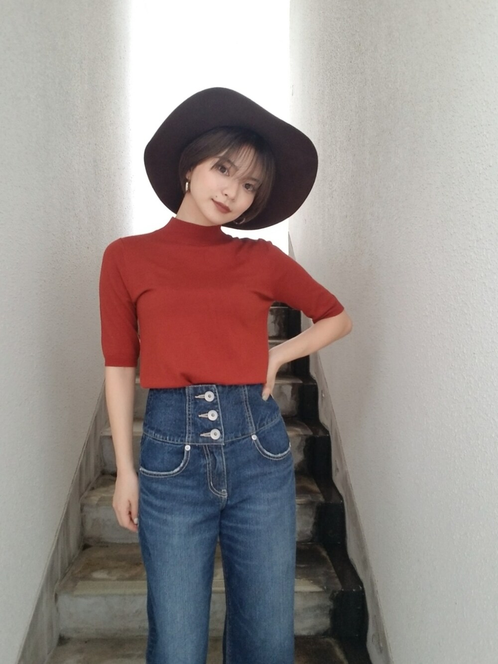 オレンジ系のニット/セーター、ブラウン系のハットを着用したレディースの夏コーディネートの2枚目の写真