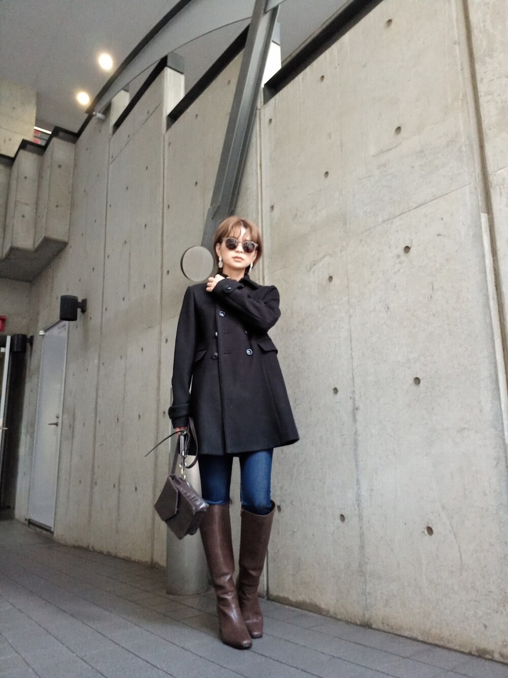 ブラウン系のブーツ、ブラウン系のショルダーバッグを着用したレディースの秋コーディネートの2枚目の写真