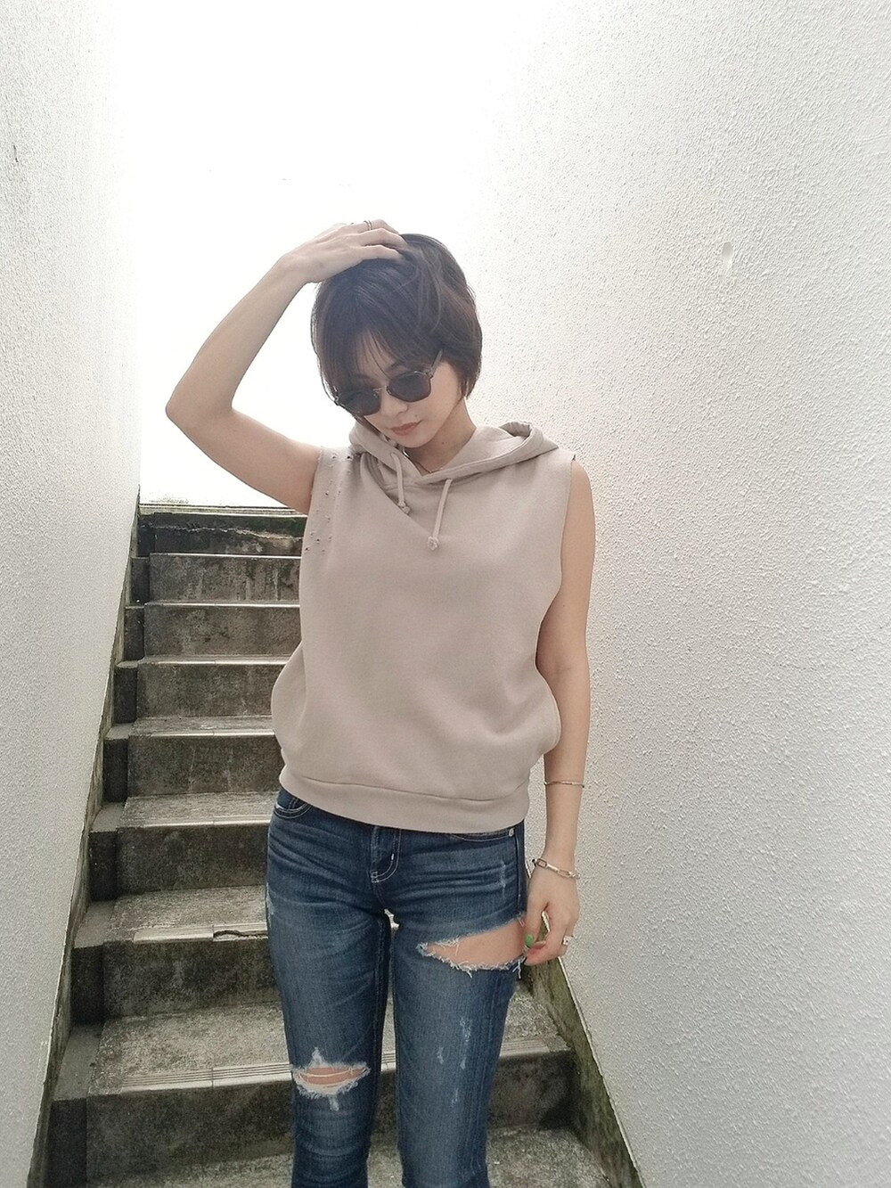 ブルー系のデニムパンツ、ベージュ系のパーカーを着用したレディースの夏コーディネートの2枚目の写真