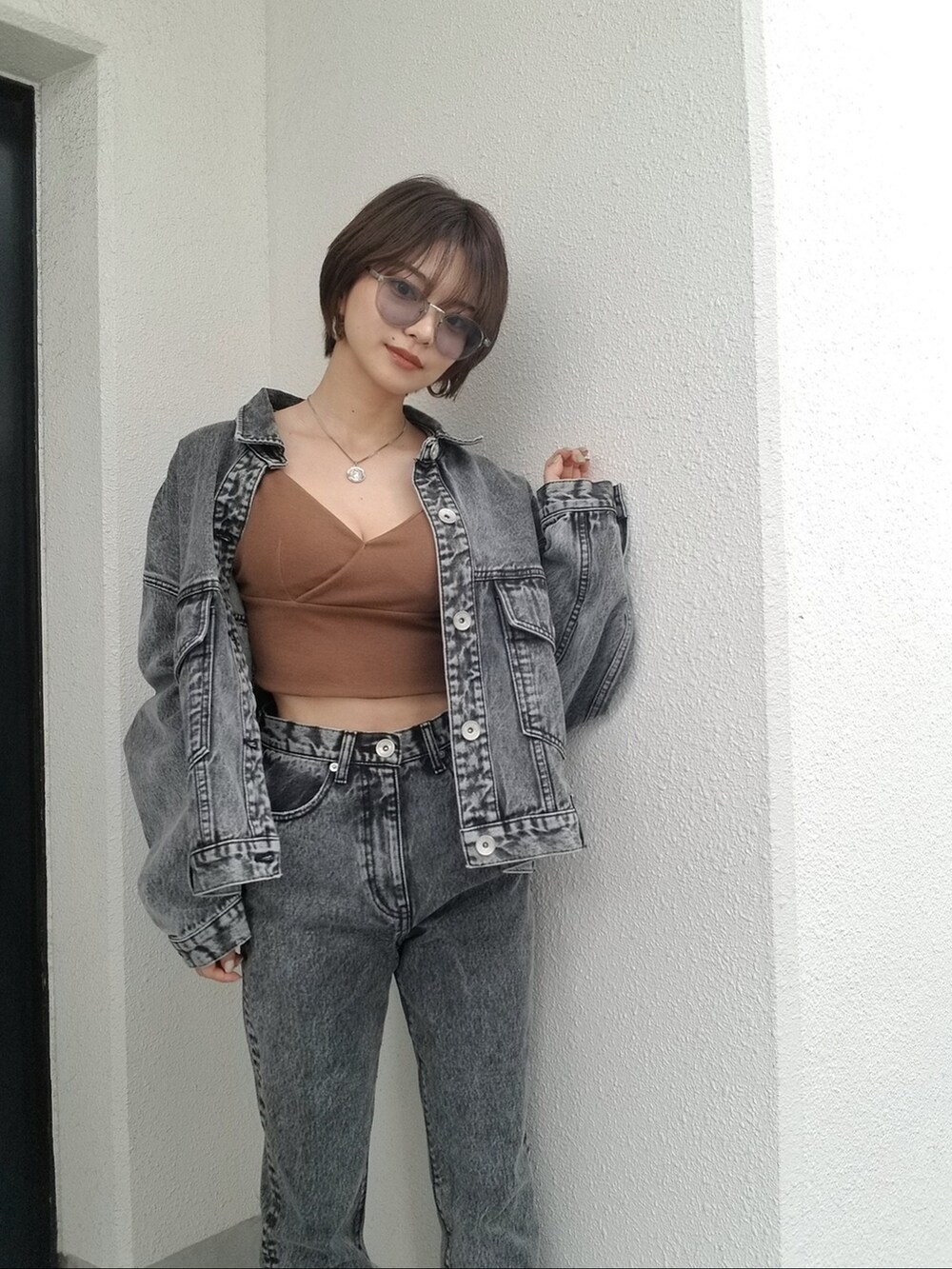 ブラック系のデニムパンツ、ブラウン系のキャミソールを着用したレディースの夏コーディネートの4枚目の写真