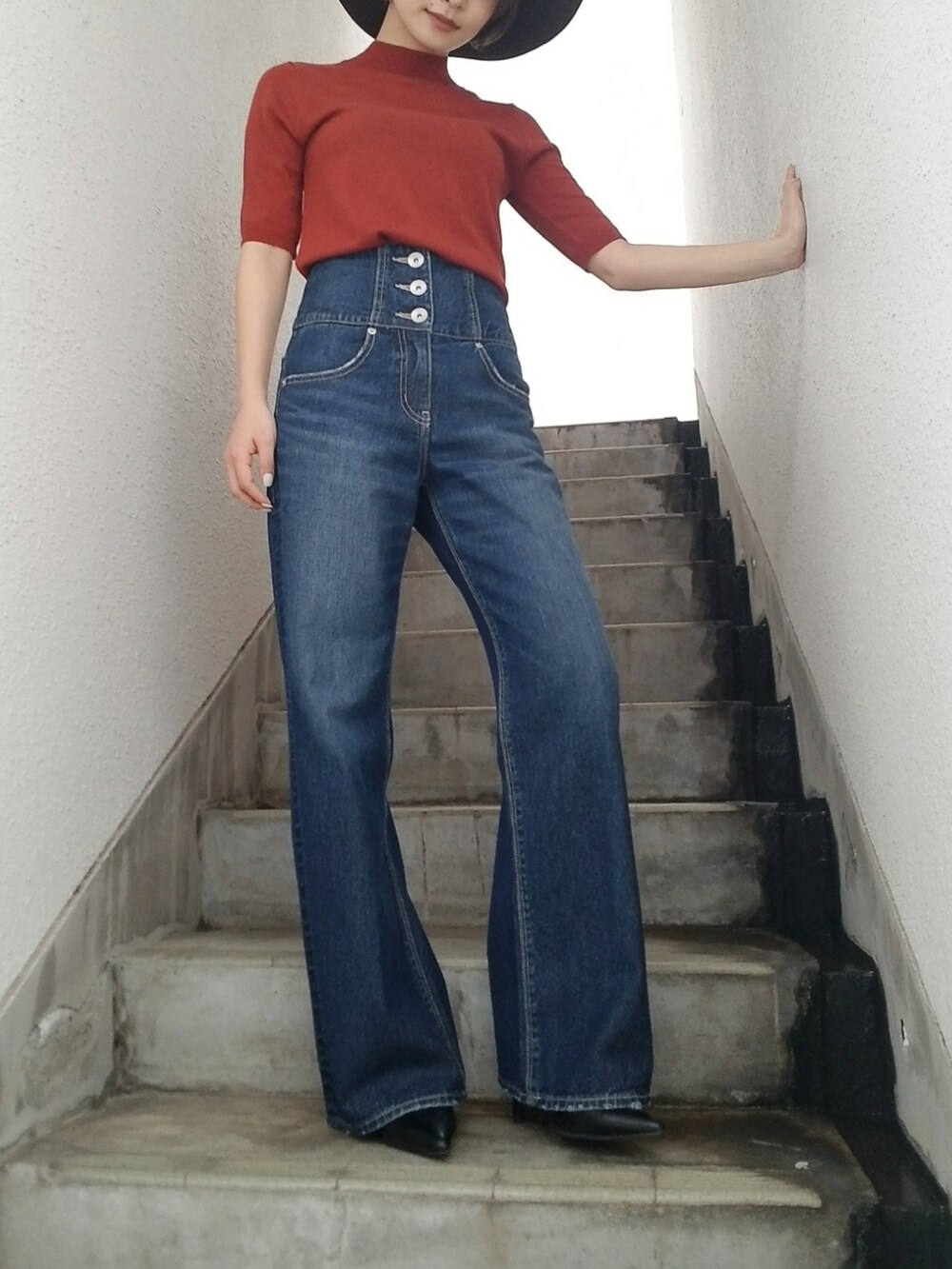 オレンジ系のニット/セーター、ブラウン系のハットを着用したレディースの夏コーディネートの4枚目の写真