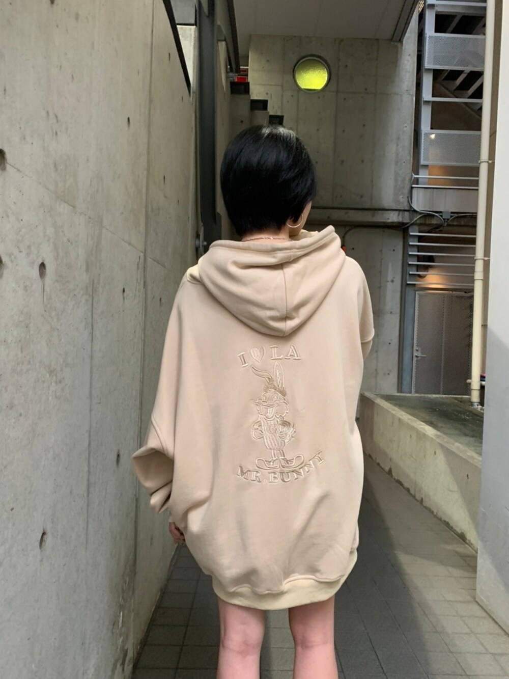 ベージュ系のパーカーを着用したレディースの夏コーディネートの2枚目の写真