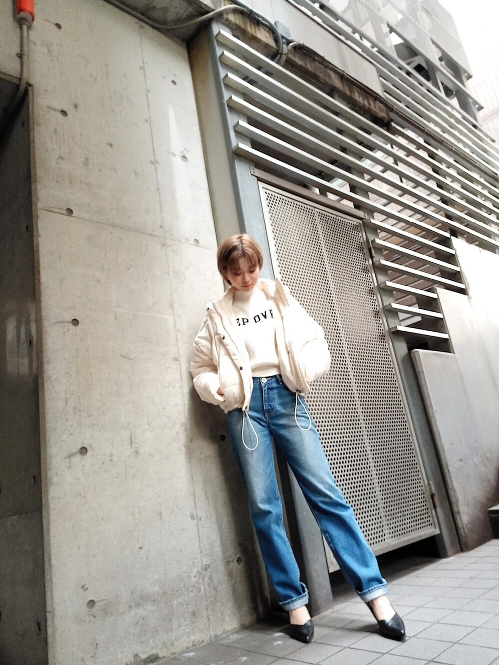 ホワイト系のダウンジャケット/コート、ブルー系のデニムパンツ、ホワイト系のニット/セーターを着用したレディースの秋コーディネートの3枚目の写真