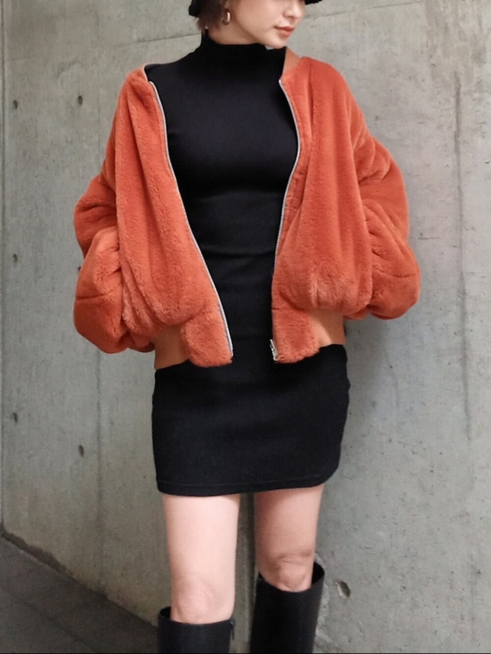 ブラック系のワンピース、ベージュ系のMA-1、ブラック系のブーツを着用したレディースの秋コーディネートの2枚目の写真