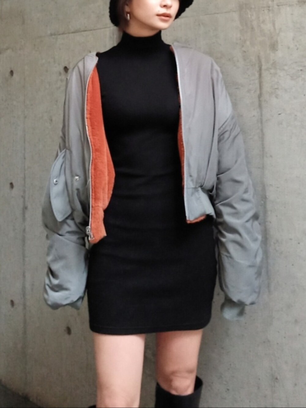 ブラック系のワンピース、ベージュ系のMA-1、ブラック系のブーツを着用したレディースの秋コーディネートの3枚目の写真