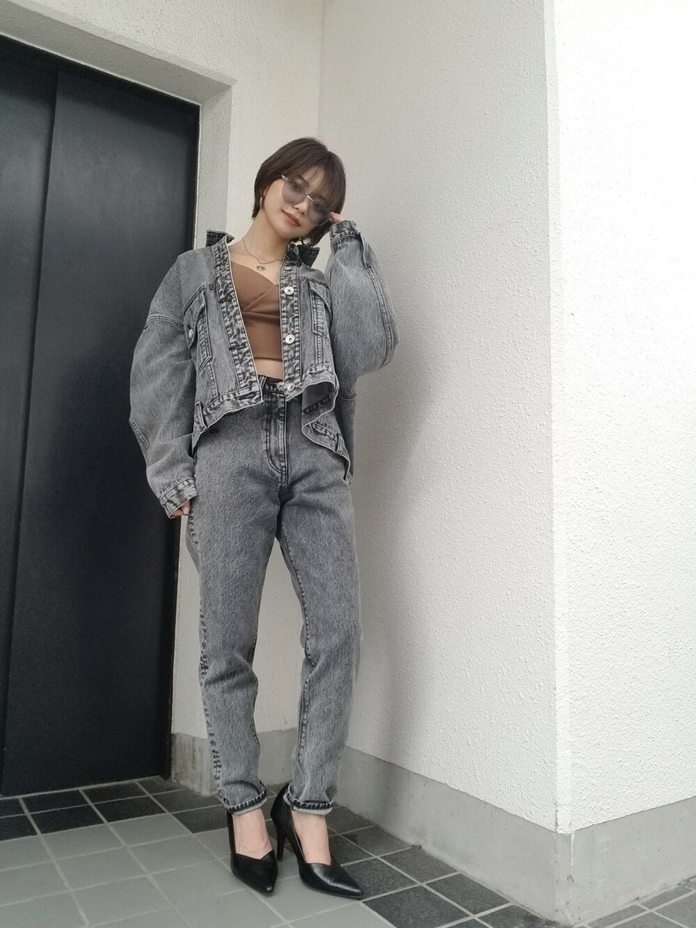 ブラック系のデニムパンツ、ブラウン系のキャミソールを着用したレディースの夏コーディネートの2枚目の写真