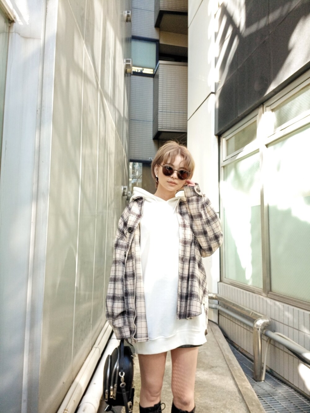 ブラック系のブーツ、ホワイト系のシャツ/ブラウス、ホワイト系のパーカーを着用したレディースの秋コーディネートの2枚目の写真