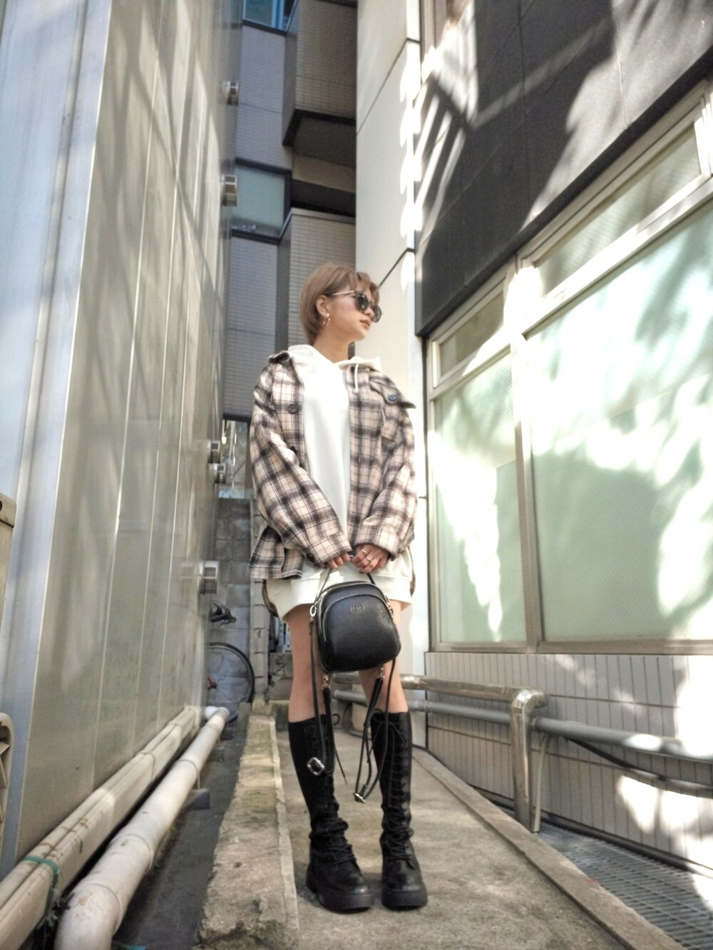 ブラック系のブーツ、ホワイト系のシャツ/ブラウス、ホワイト系のパーカーを着用したレディースの秋コーディネートの3枚目の写真