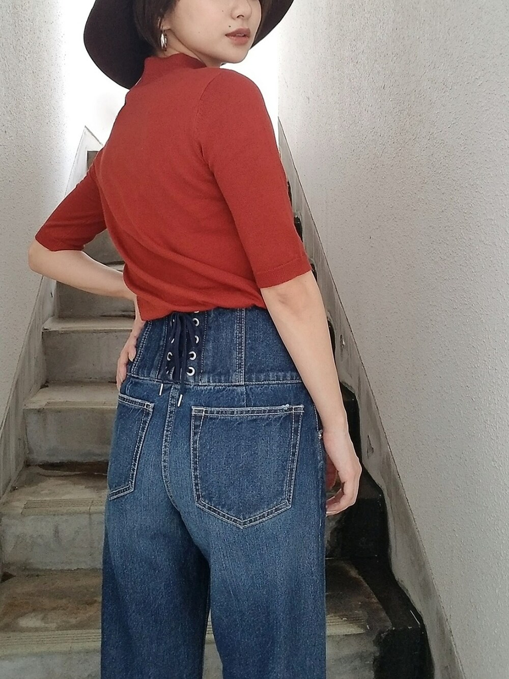 オレンジ系のニット/セーター、ブラウン系のハットを着用したレディースの夏コーディネートの3枚目の写真