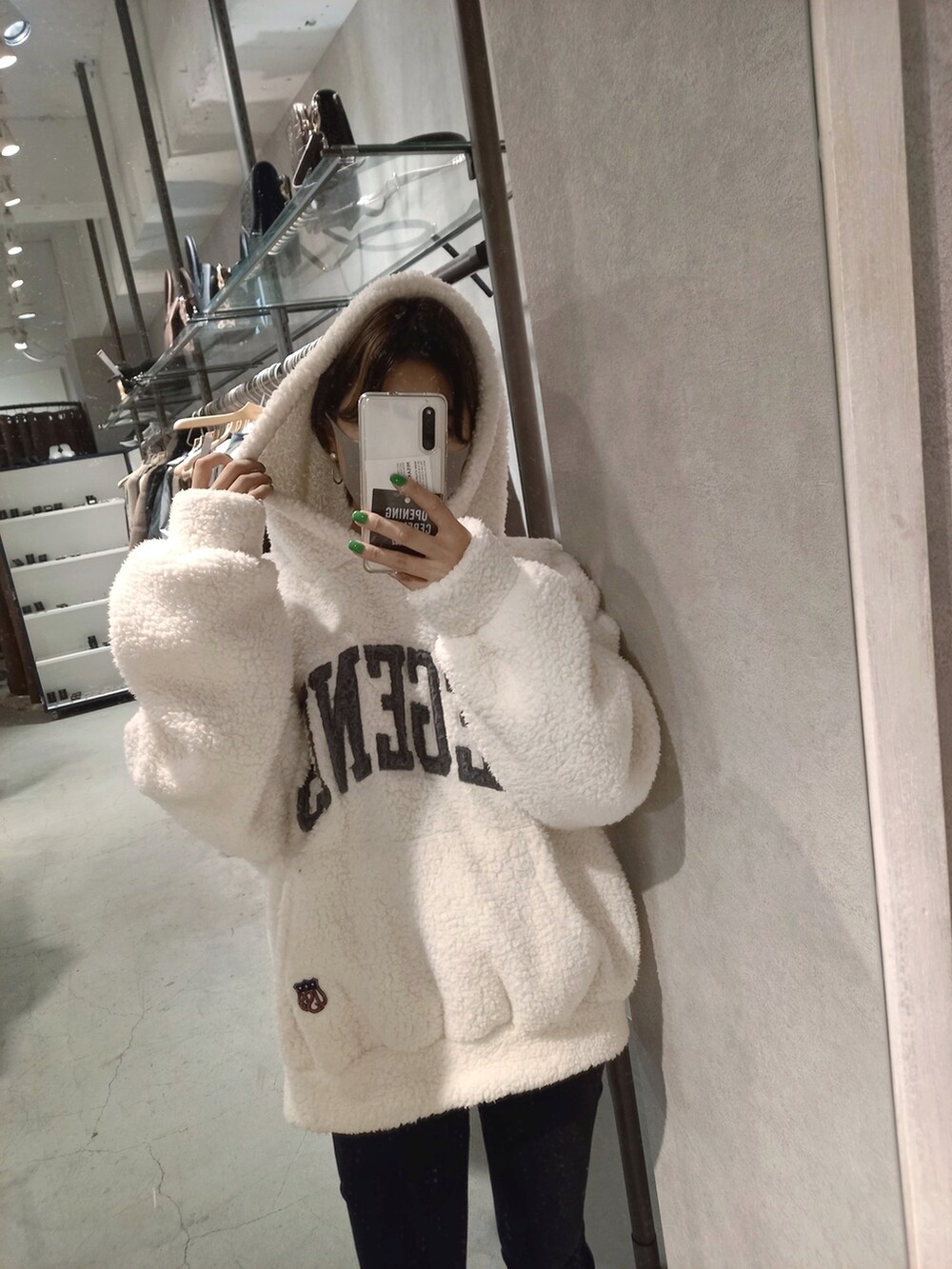 ブラック系のデニムパンツ、ホワイト系のパーカーを着用したレディースの秋コーディネートの2枚目の写真