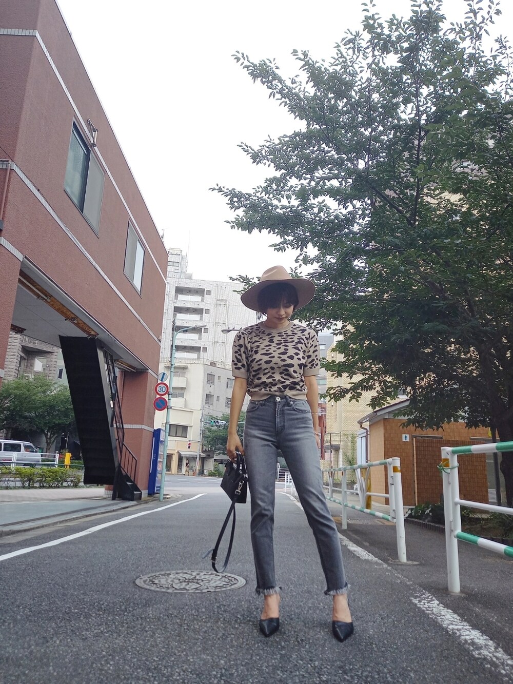 ブラック系のパンプス、ベージュ系のハットを着用したレディースの夏コーディネートの2枚目の写真