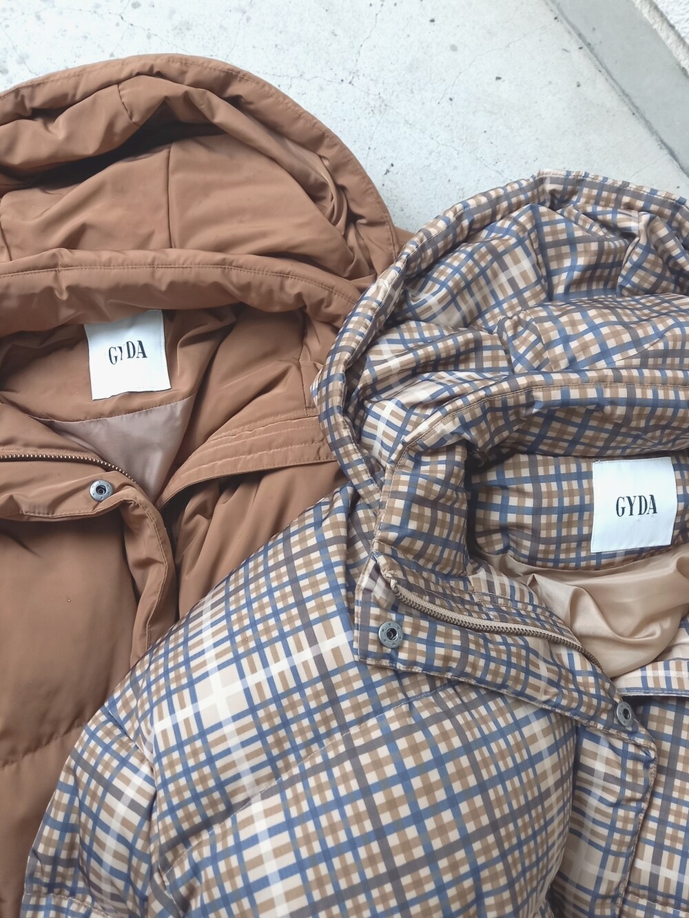 ブラック系のダウンジャケット/コート、ブラック系のワンピース、ブラウン系のブーツを着用したレディースの秋コーディネートの4枚目の写真