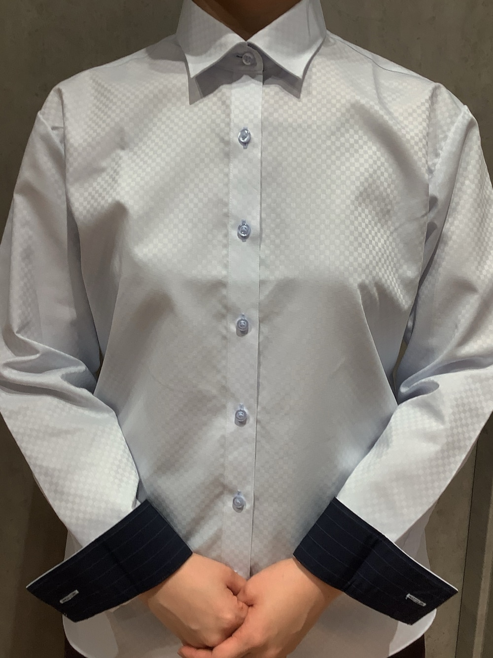 ブルー系のビジネスシャツを着用したレディースの冬コーディネートの2枚目の写真