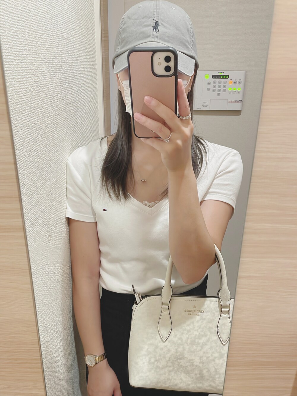 ホワイト系のハンドバッグ、ホワイト系のTシャツ/カットソー、ブラック系のスカートを着用したレディースの夏コーディネートの2枚目の写真