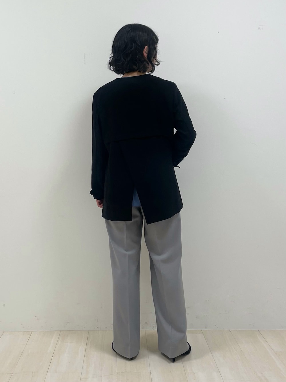 グレー系のスーツパンツ、ブルー系のシャツ/ブラウス、ブラック系のノーカラージャケットを着用したレディースの春コーディネートの3枚目の写真