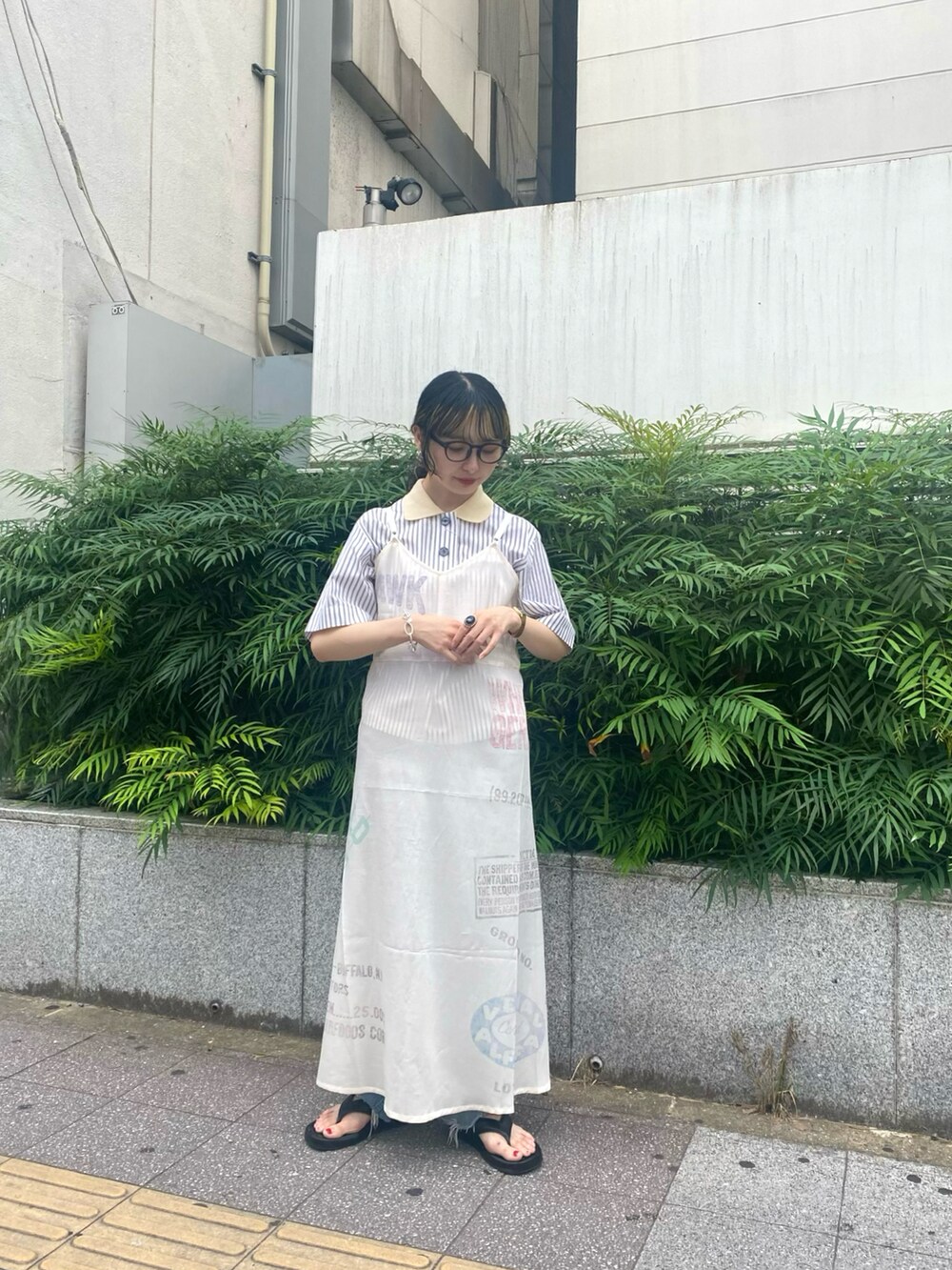 ホワイト系のトップス、ホワイト系のドレス、ブラック系のサンダルを着用したレディースの夏コーディネートの2枚目の写真