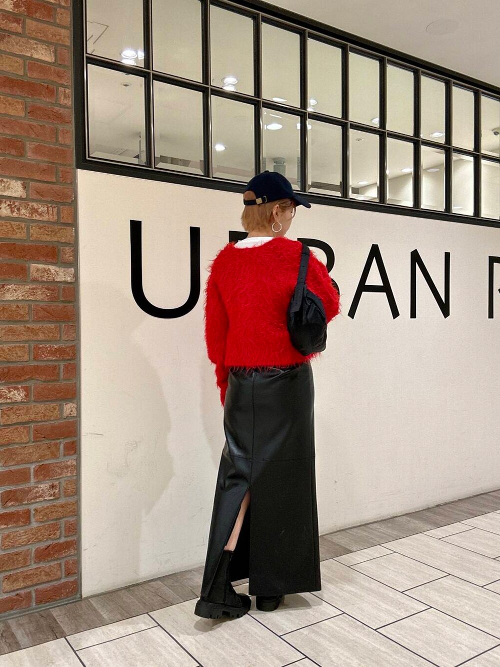 ブラック系のブーツ、ブラック系のスカート、レッド系のカーディガン/ボレロを着用したレディースの冬コーディネートの3枚目の写真