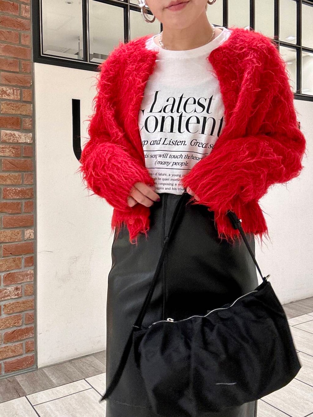 ブラック系のブーツ、ブラック系のスカート、レッド系のカーディガン/ボレロを着用したレディースの冬コーディネートの4枚目の写真