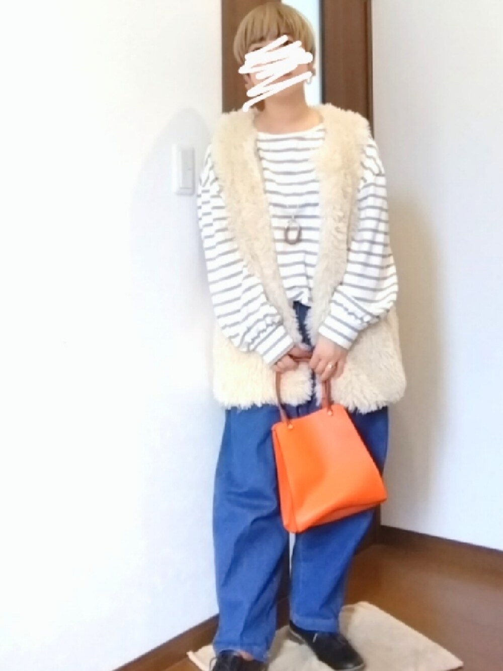 ベージュ系のTシャツ/カットソー、ブルー系のデニムパンツ、ブラウン系のダウンベストを着用したレディースの秋コーディネートの2枚目の写真