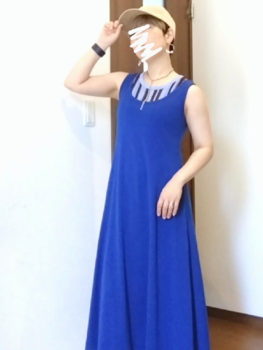 ブルー系のデニムパンツ、ブルー系のタンクトップ、ホワイト系のサンダルを着用したレディースの夏コーディネートの3枚目の写真