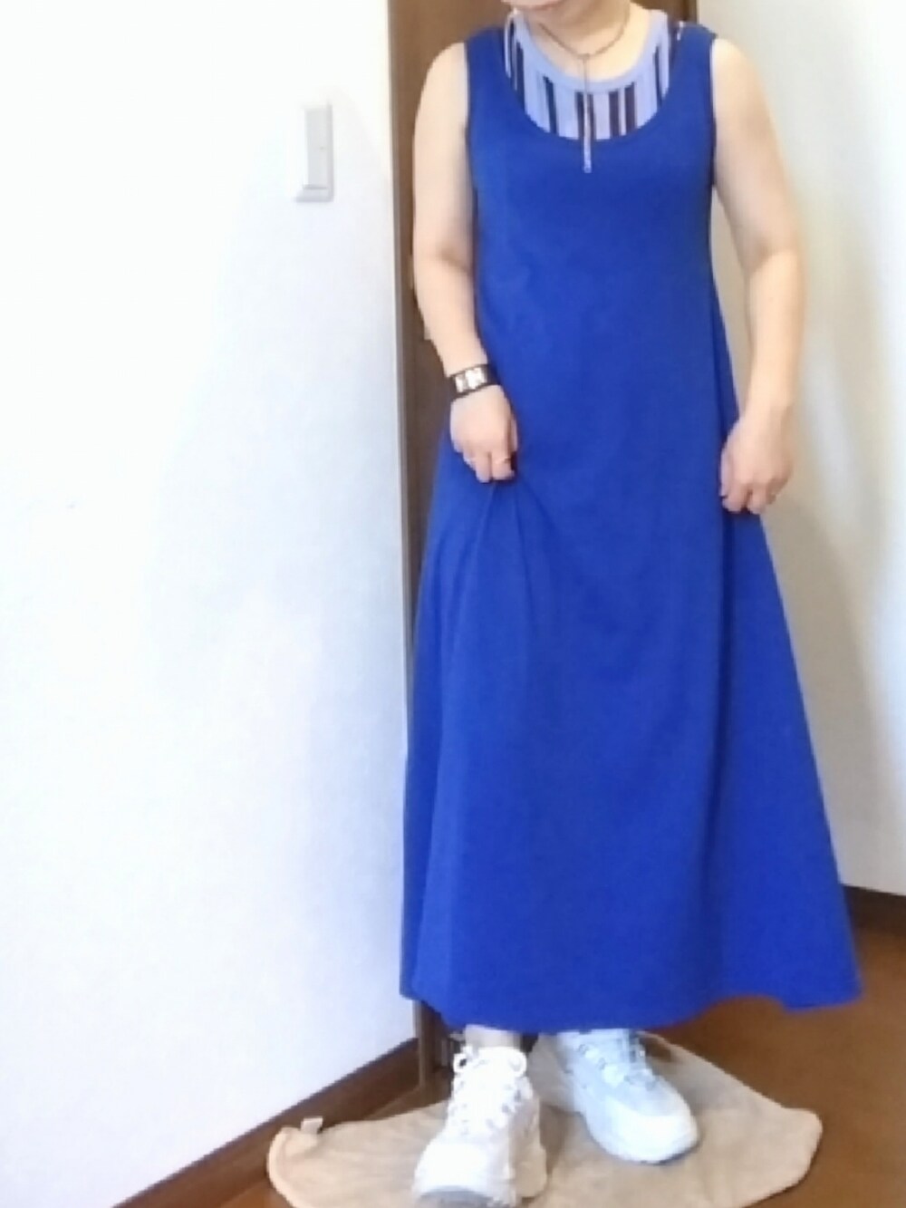 ブルー系のデニムパンツ、ブルー系のタンクトップ、ホワイト系のサンダルを着用したレディースの夏コーディネートの4枚目の写真