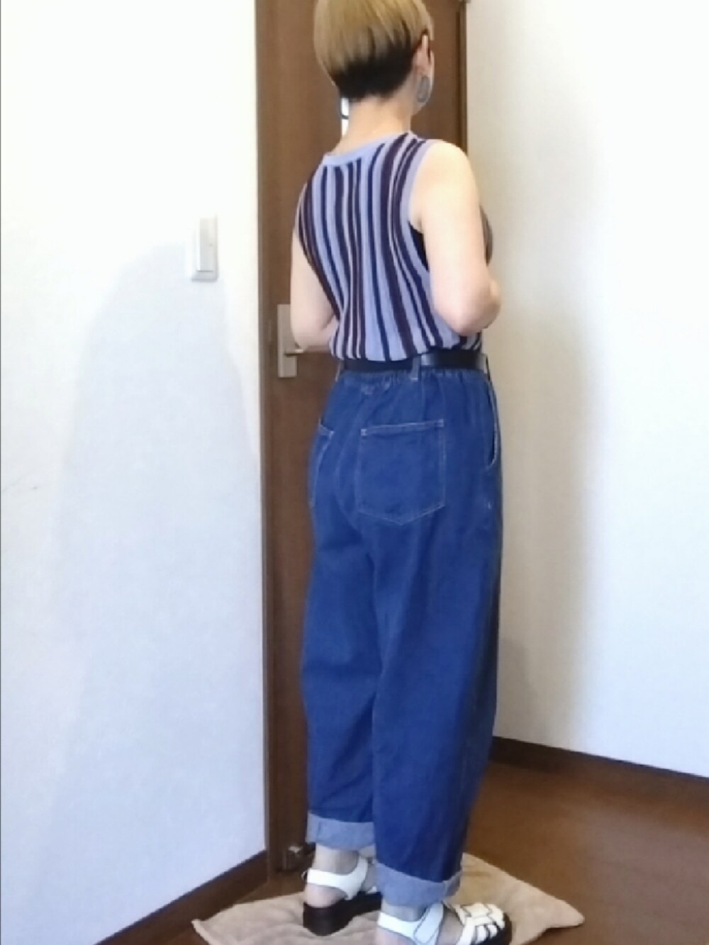 ブルー系のデニムパンツ、ブルー系のタンクトップ、ホワイト系のサンダルを着用したレディースの夏コーディネートの2枚目の写真