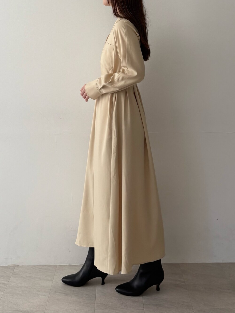 イエロー系のワンピース、ブラック系のブーツを着用したレディースの秋コーディネートの2枚目の写真