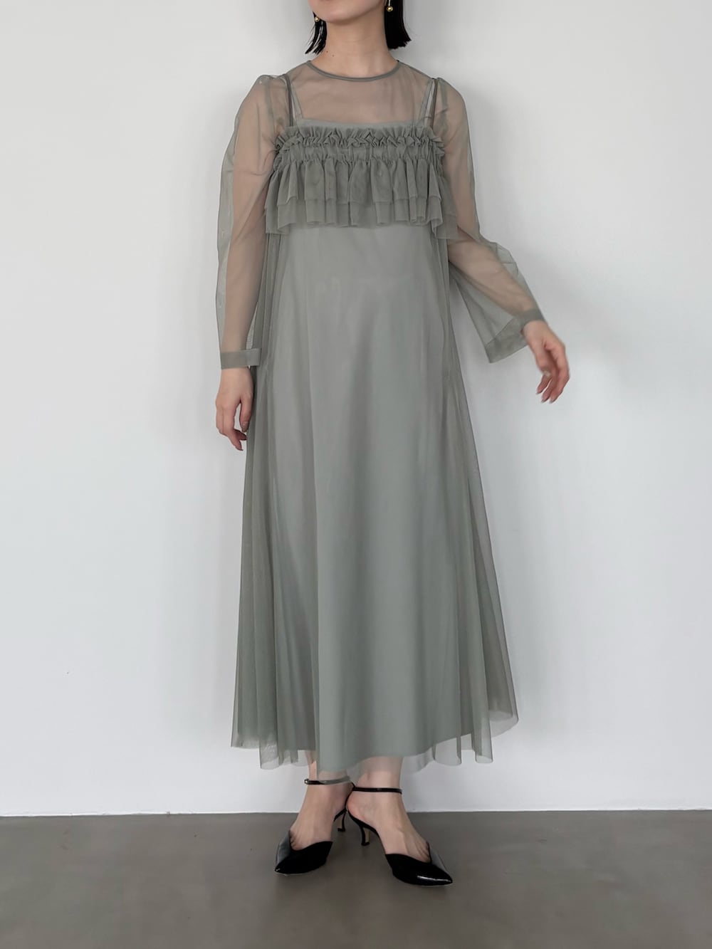 グリーン系のワンピースを着用したレディースの冬コーディネートの2枚目の写真