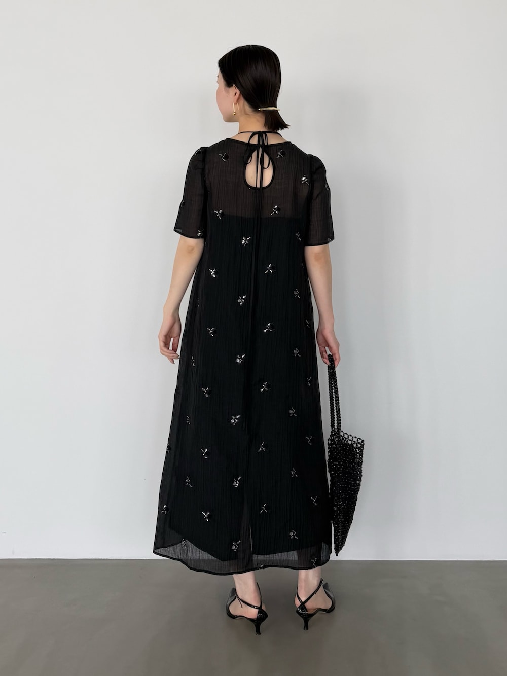 ブラック系のワンピースを着用したレディースの春コーディネートの4枚目の写真