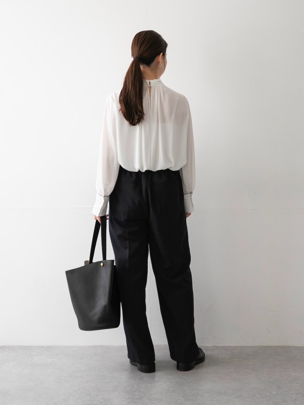 ブルー系のその他パンツ、ブラック系のトートバッグ、ホワイト系のシャツ/ブラウスを着用したレディースの秋コーディネートの2枚目の写真