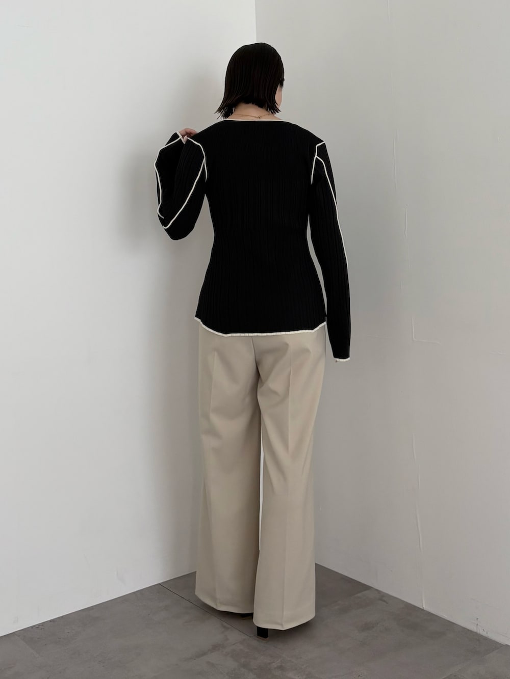 ブラック系のニット/セーター、ベージュ系のその他パンツを着用したレディースの春コーディネートの3枚目の写真