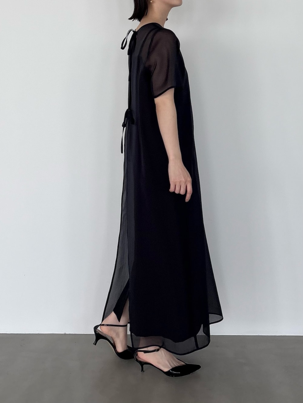 ブラック系のワンピースを着用したレディースの春コーディネートの2枚目の写真