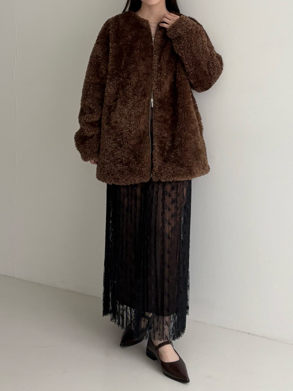 ブラウン系のノーカラージャケット、ブラック系のスカートを着用したレディースの秋コーディネートの2枚目の写真