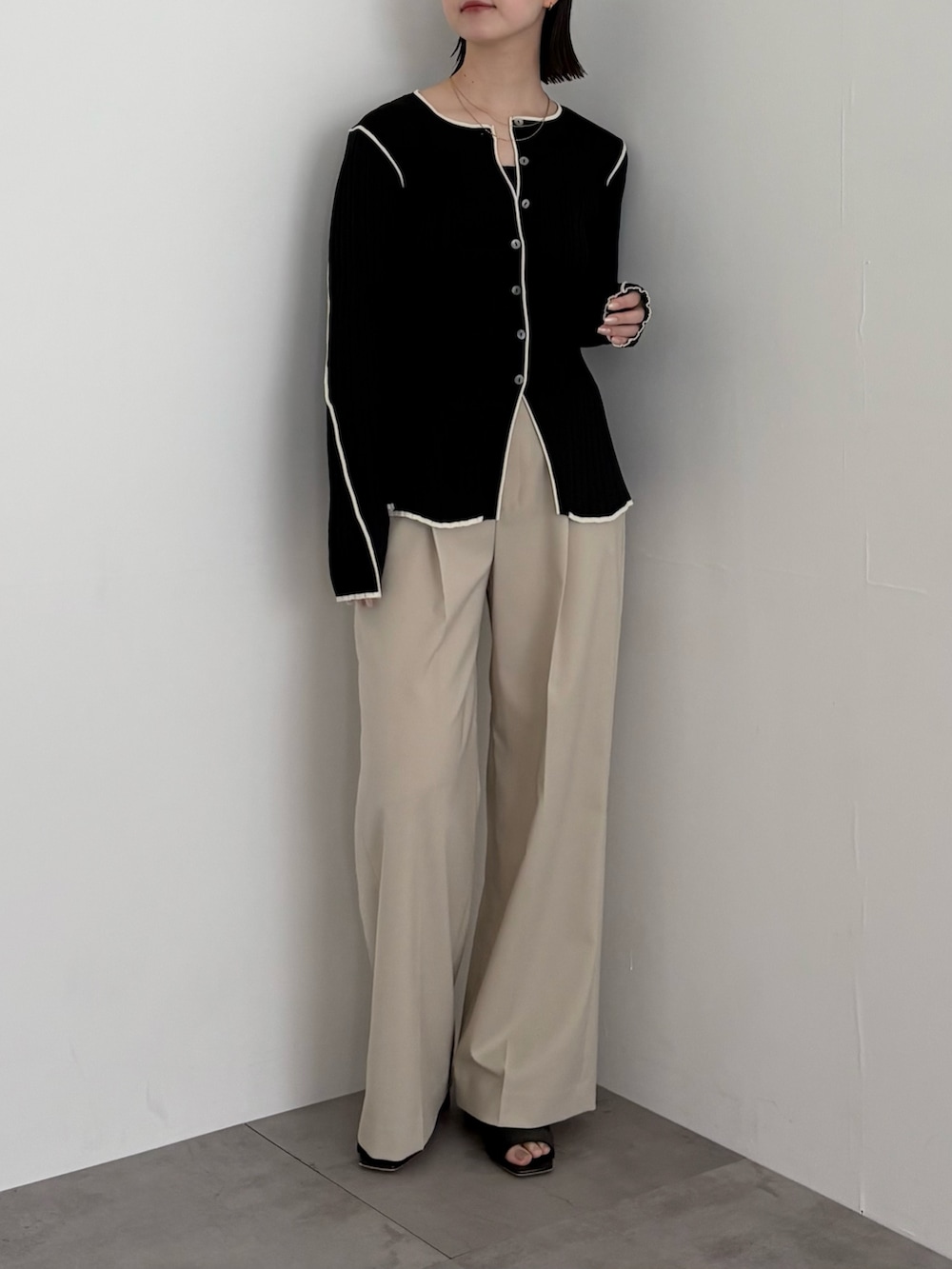 ブラック系のニット/セーター、ベージュ系のその他パンツを着用したレディースの春コーディネートの2枚目の写真
