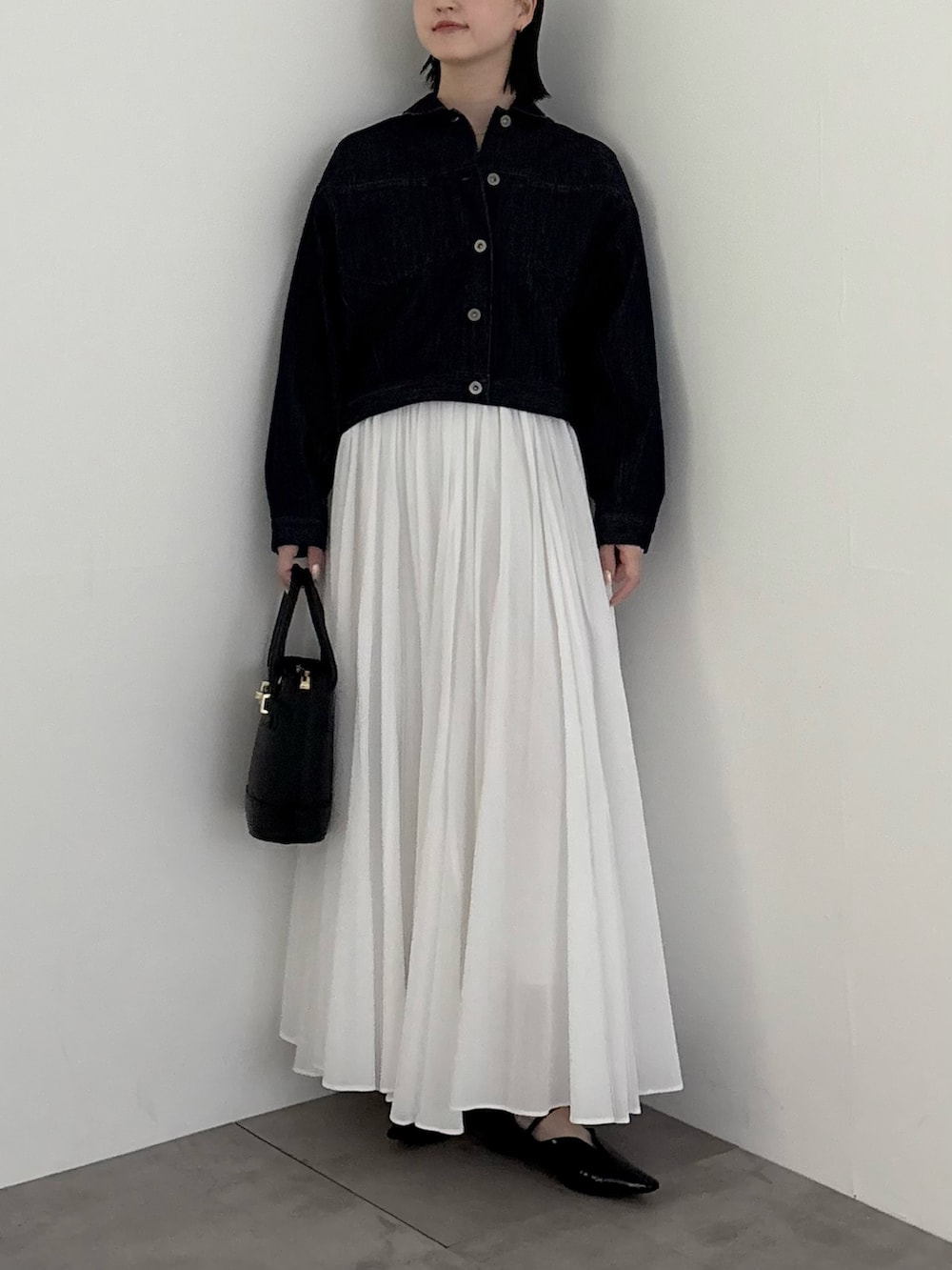 ブルー系のデニムジャケット、ホワイト系のスカートを着用したレディースの冬コーディネートの2枚目の写真