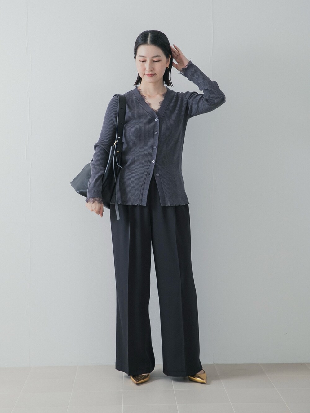 ブラック系のその他パンツ、ゴールド系のパンプス、グレー系のニット/セーターを着用したレディースの秋コーディネートの3枚目の写真