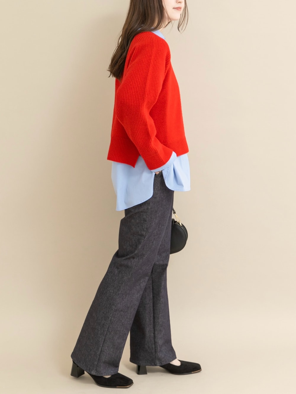 レッド系のニット/セーター、ブラック系のパンプスを着用したレディースの冬コーディネートの2枚目の写真