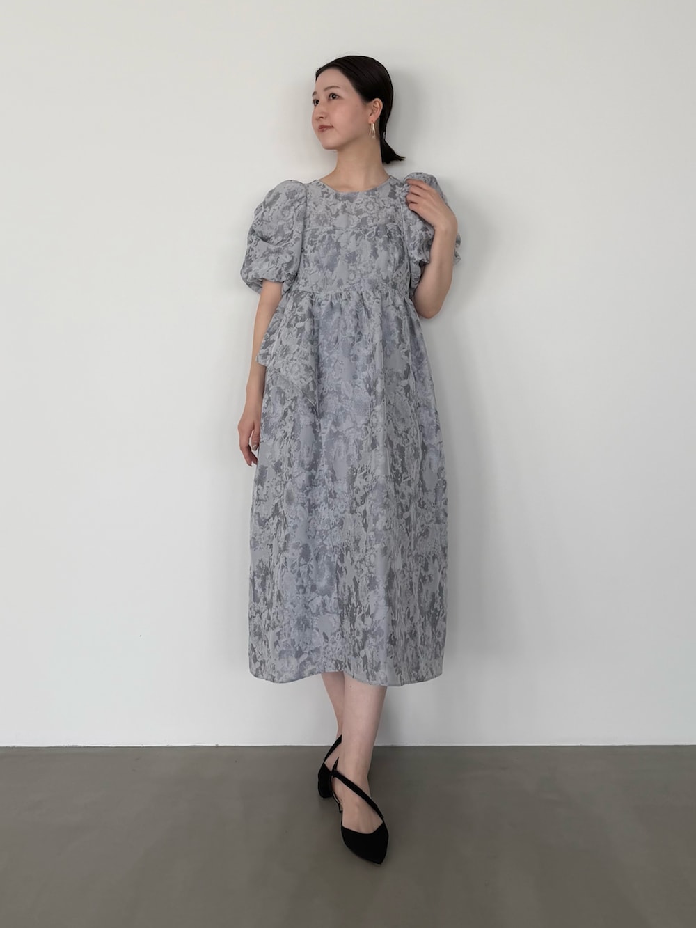 グレー系のワンピース、ブラック系のシューズ小物/雑貨を着用したレディースの冬コーディネートの2枚目の写真