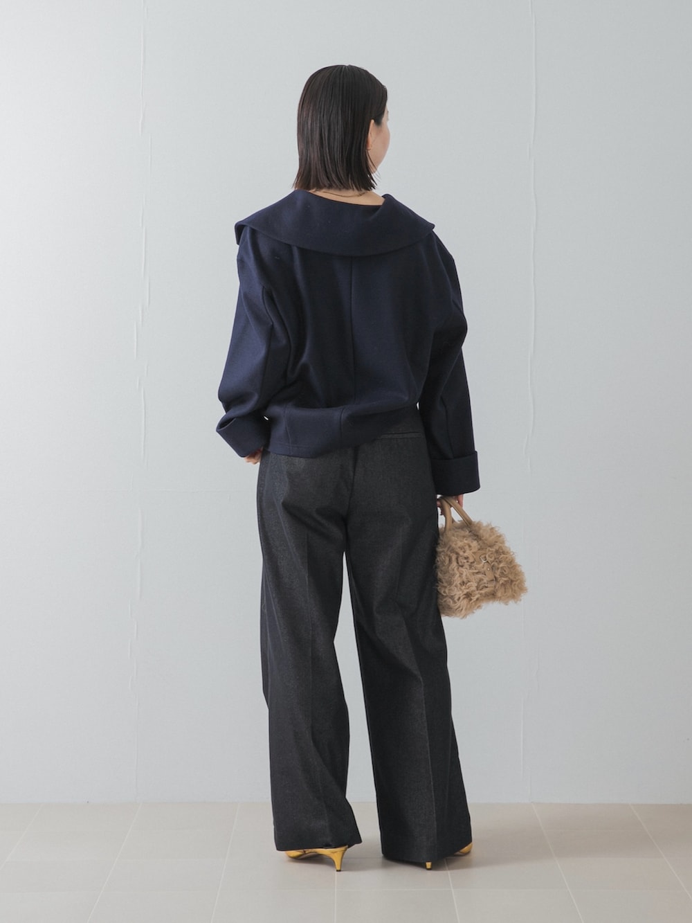 ブルー系のその他トップス、ゴールド系のパンプス、イエロー系のハンドバッグを着用したレディースの秋コーディネートの3枚目の写真