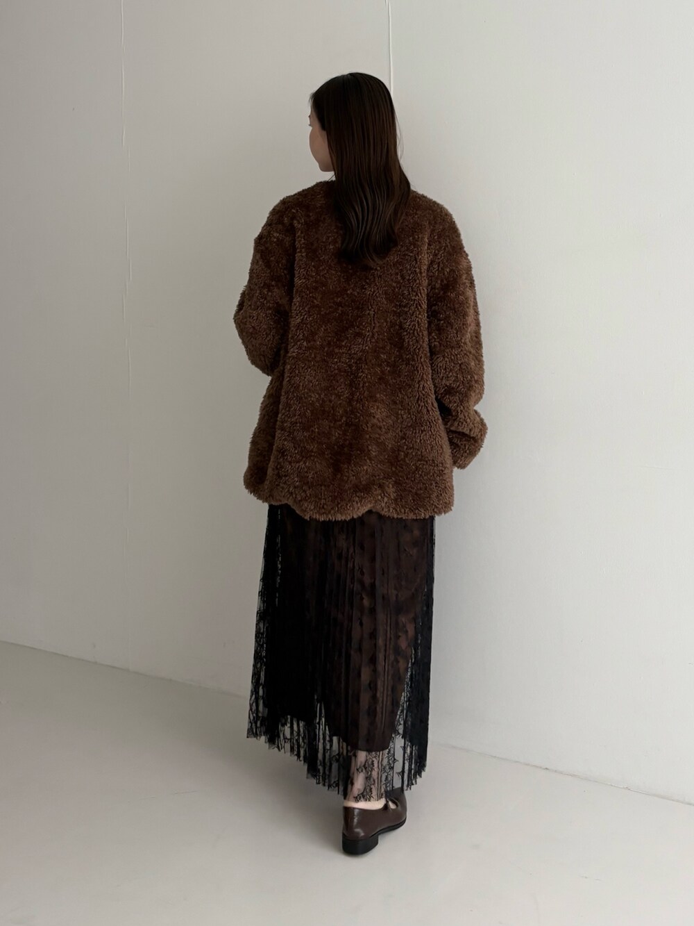 ブラウン系のノーカラージャケット、ブラック系のスカートを着用したレディースの秋コーディネートの3枚目の写真