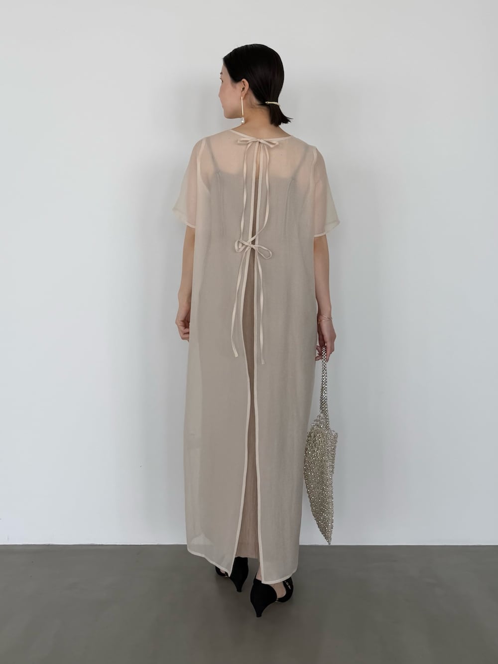 ホワイト系のワンピース、ブラック系のシューズ小物/雑貨を着用したレディースの春コーディネートの3枚目の写真