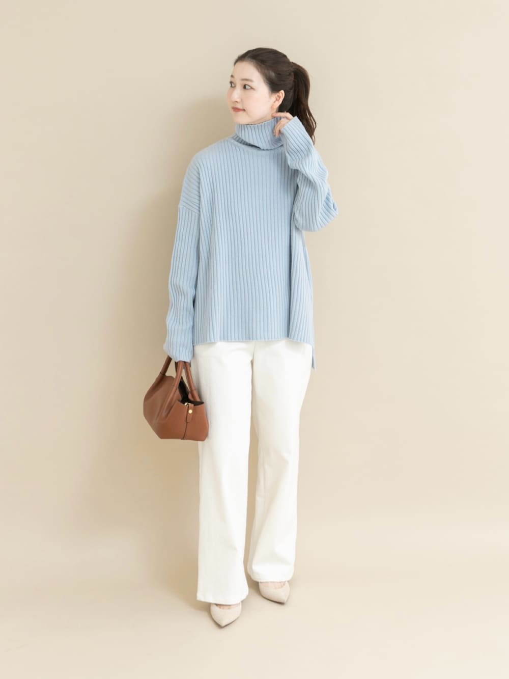 ブルー系のニット/セーター、ホワイト系のデニムパンツを着用したレディースの冬コーディネートの3枚目の写真