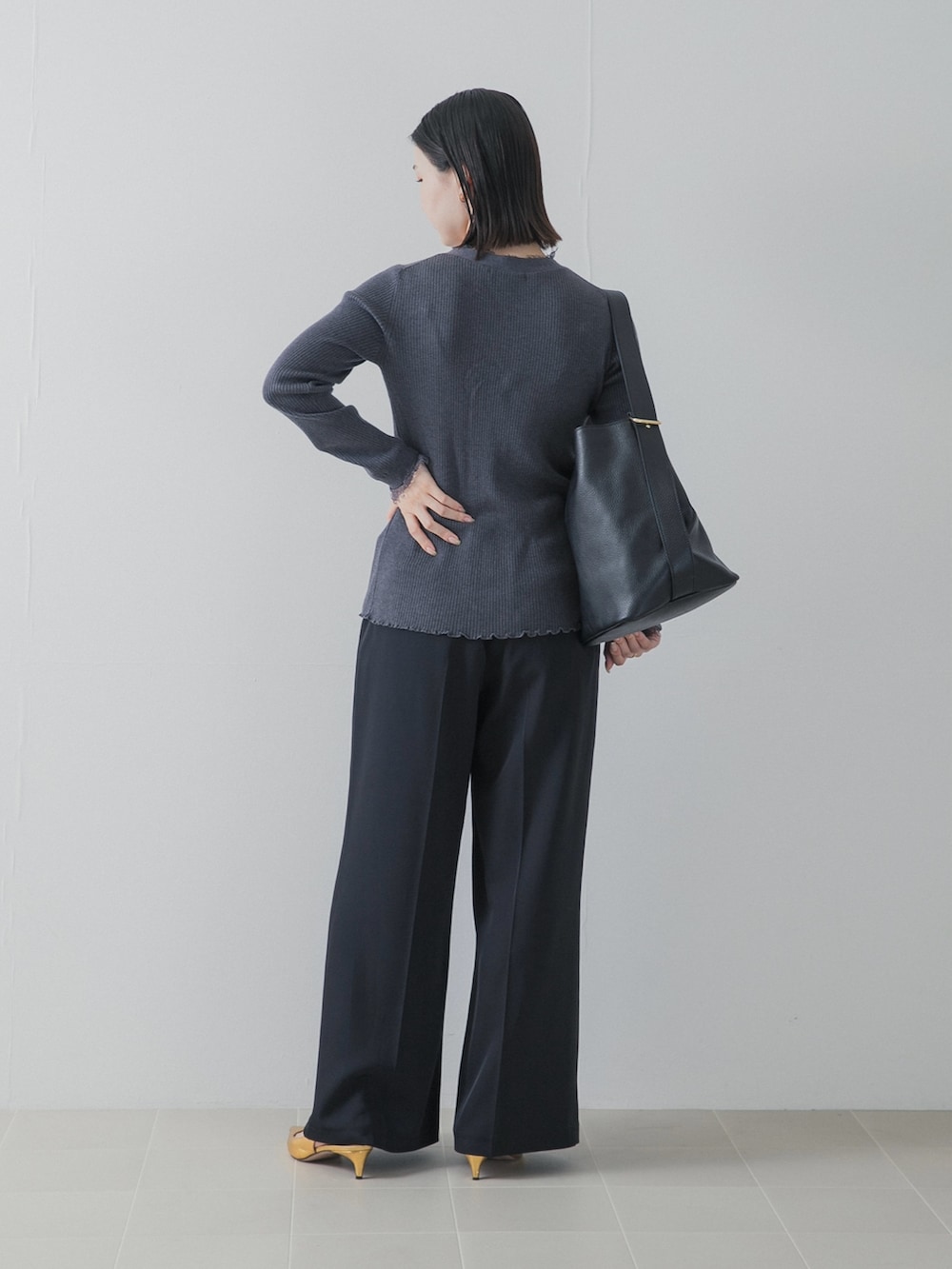 ブラック系のその他パンツ、ゴールド系のパンプス、グレー系のニット/セーターを着用したレディースの秋コーディネートの5枚目の写真