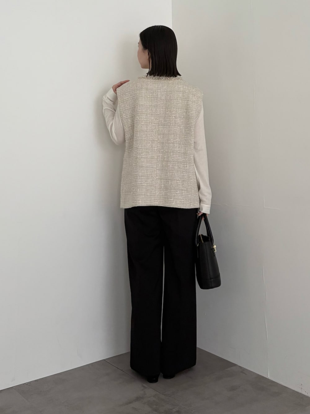 ベージュ系のベスト、ブラック系のその他パンツを着用したレディースの冬コーディネートの3枚目の写真