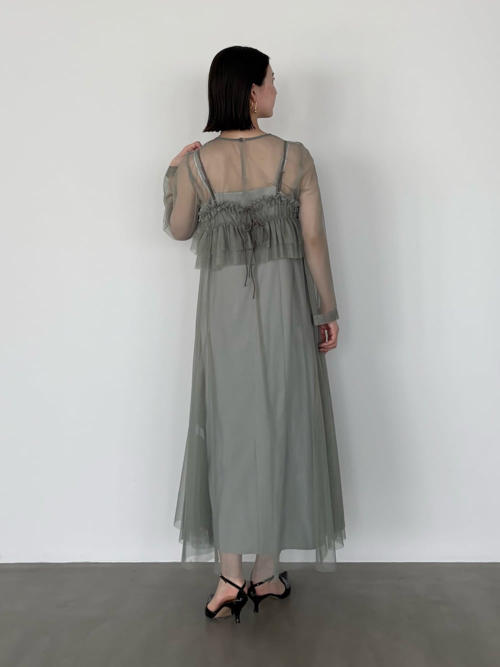 グリーン系のワンピースを着用したレディースの冬コーディネートの3枚目の写真