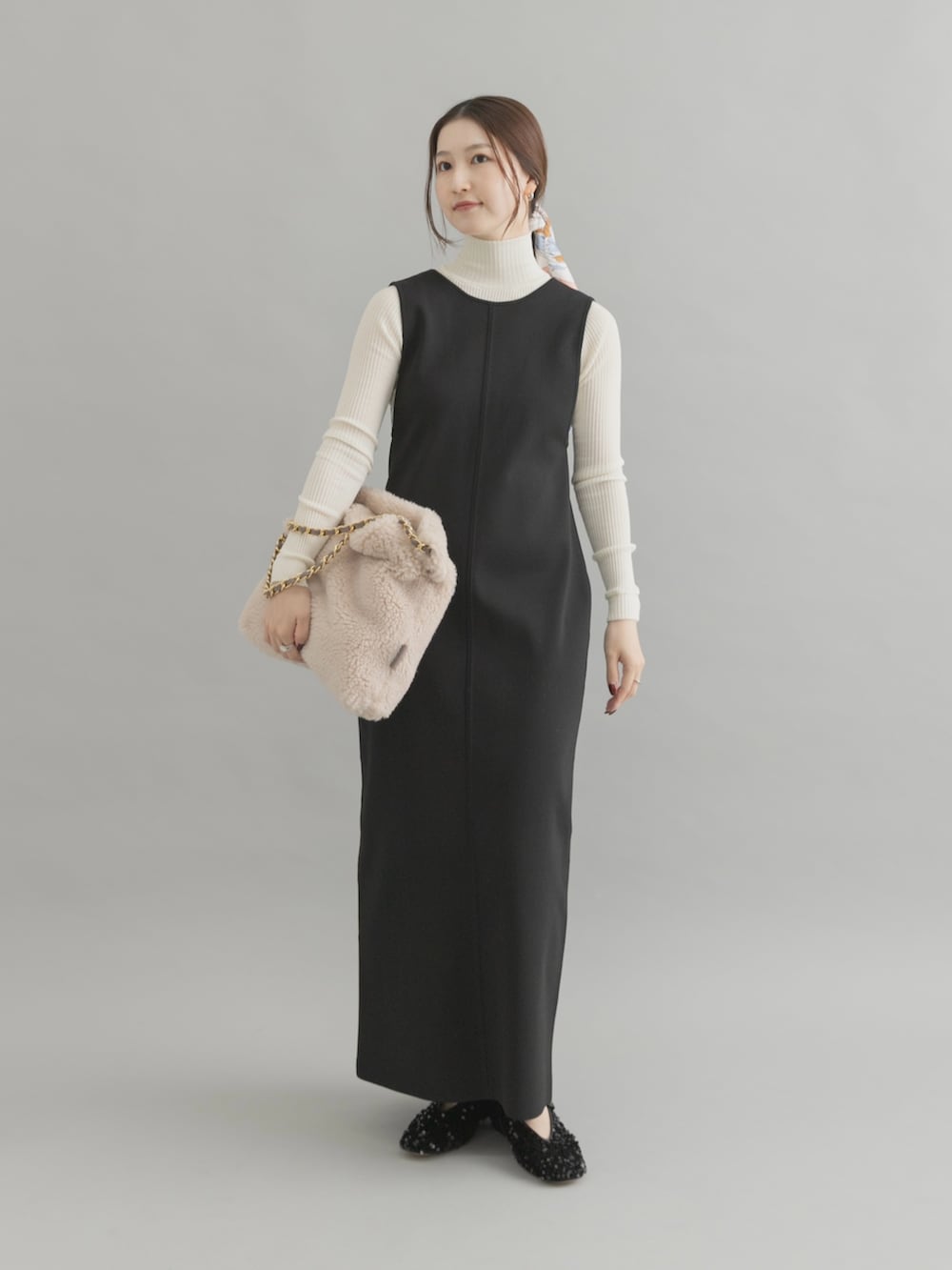 ホワイト系のショルダーバッグ、ブラック系のパンプス、ブラック系のワンピースを着用したレディースの秋コーディネートの2枚目の写真