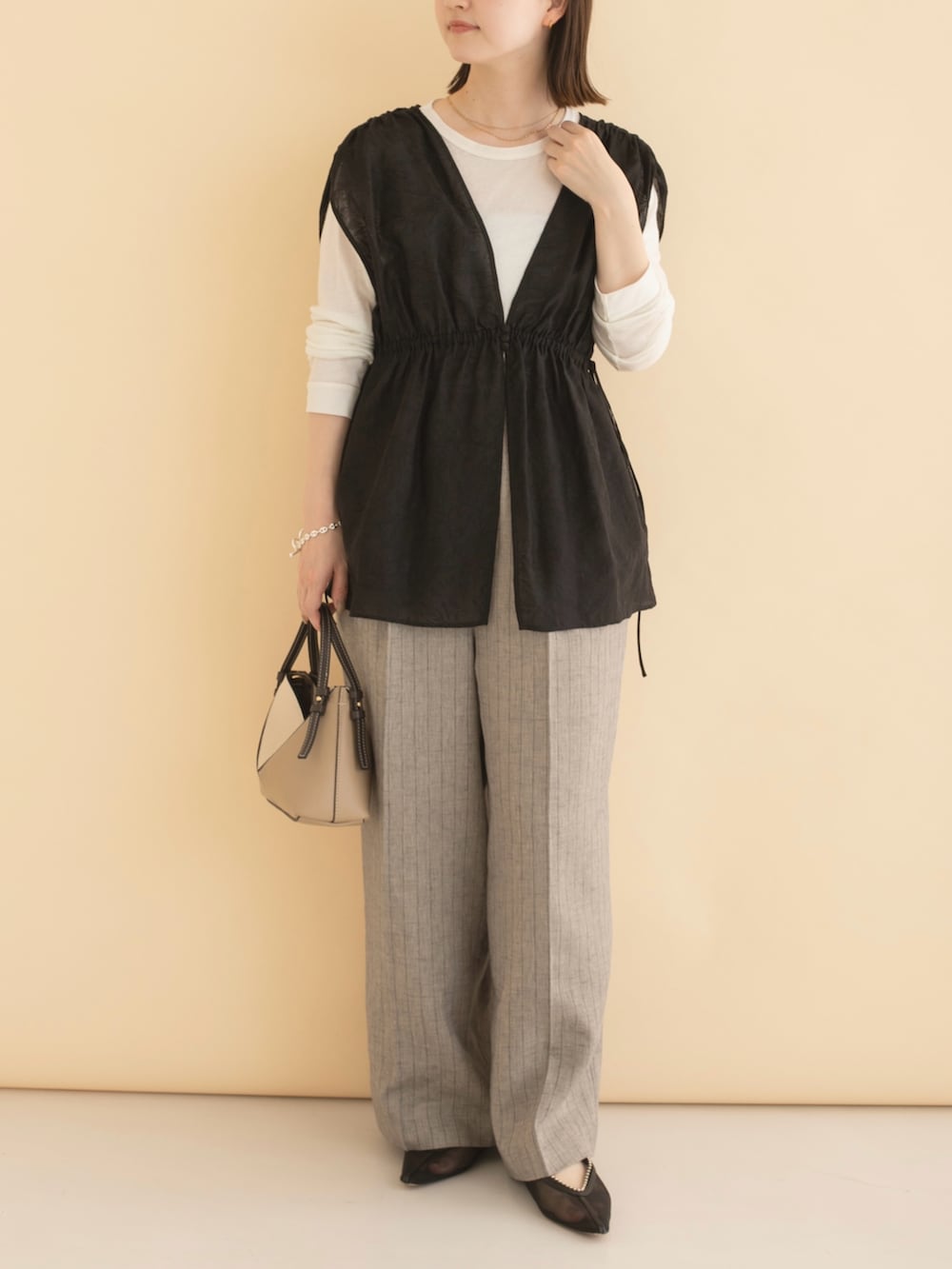 ブラック系のその他トップス、グレー系のその他パンツ、ホワイト系のTシャツ/カットソーを着用したレディースの冬コーディネートの2枚目の写真