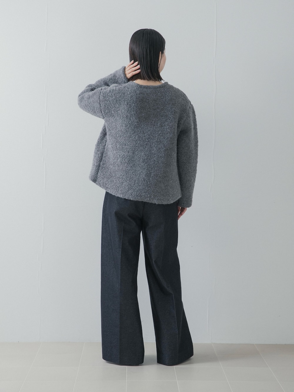ブルー系のデニムパンツ、シルバー系のパンプス、グレー系のノーカラージャケットを着用したレディースの秋コーディネートの4枚目の写真