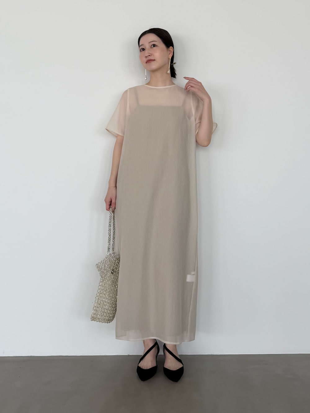 ホワイト系のワンピース、ブラック系のシューズ小物/雑貨を着用したレディースの春コーディネートの2枚目の写真