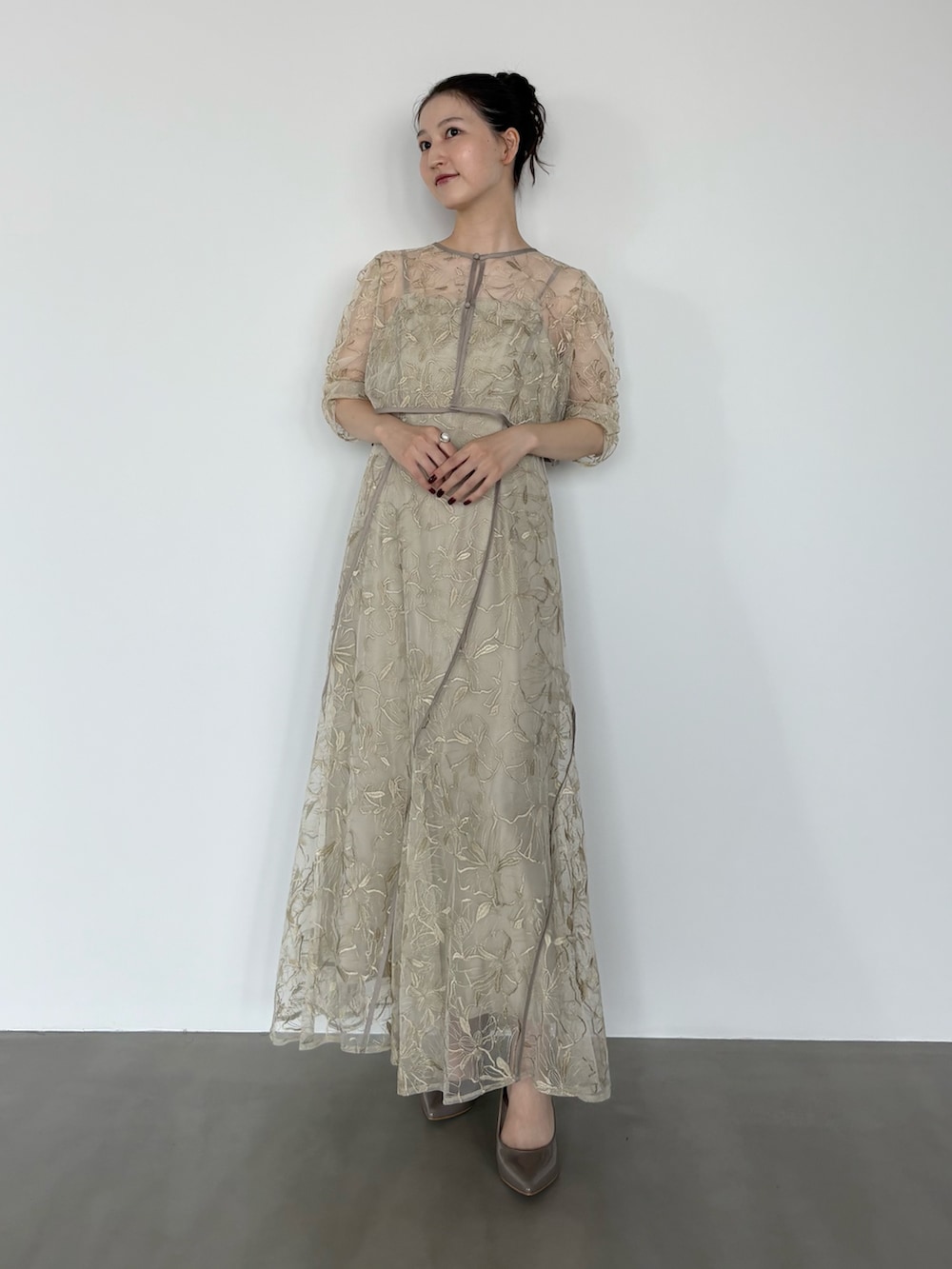 グリーン系のワンピース、グレー系のパンプスを着用したレディースの秋コーディネートの2枚目の写真